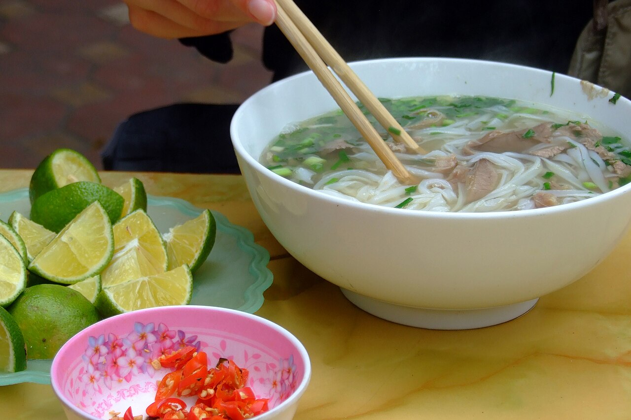 Bowl of Vietnamese pho bo with limes and chilies